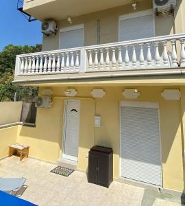 a yellow house with a balcony and a door at Cozy blue in Ialyssos