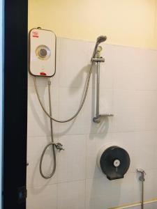 eine Dusche im Bad mit einem Schlauch an der Wand in der Unterkunft Thunyaporn Hostel in Trang