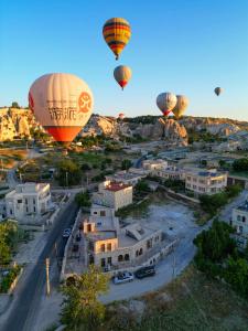 een groep heteluchtballonnen die over een stad vliegen bij Premium Cappadocia House in Goreme