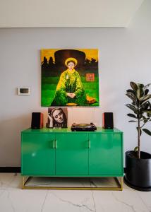 a green cabinet in a room with a painting on the wall at Lux Executive Residence @ Empire City by CIRCADIAN in Ho Chi Minh City