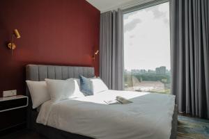 - une chambre avec un lit blanc et une grande fenêtre dans l'établissement Lux Executive Residence @ Empire City by CIRCADIAN, à Hô-Chi-Minh-Ville
