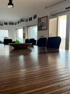 un grande tavolo in legno in una stanza con sedie di Il Paese dei Balocchi ad Alezio