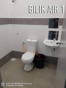 een badkamer met een wit toilet en een wastafel bij Aisyah Homestay Kuantan - Jaya Gading in Kampong Seri Permatang Gading
