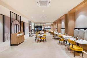 a dining room with tables and yellow chairs at 7 Apple Hotel Jal Mahal, Jaipur in Jaipur