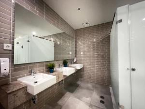 a bathroom with two sinks and a mirror at PassGo Digital Airport Terminal 2 Soekarno Hatta in Rawabagol