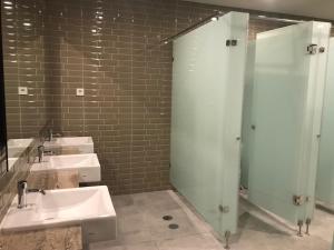 a bathroom with three sinks and a glass shower at PassGo Digital Airport Terminal 2 Soekarno Hatta in Rawabagol