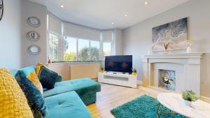 a living room with a blue couch and a fireplace at Stunning 5 Bed Detached Home Nottingham in Nottingham