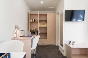 a living room with a desk and a tv in a room at Adelaide Granada Motor Inn in Adelaide +26 photos