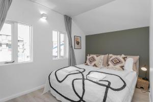 a white bedroom with a large bed with a large window at Lokastígur Charming and Inviting Apartment in Reykjavík