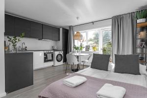 a bedroom with a large bed and a kitchen at Venture Vacation - Cozy and Central Apartment in Reykjavík