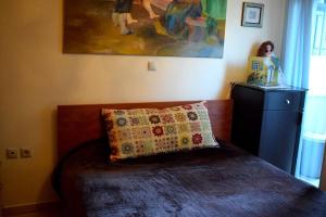 a bedroom with a bed with a pillow and a painting at Helen's Cozy Apartment in Litochoro