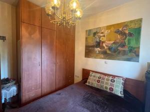 um quarto com uma cama e um quadro na parede em Helen's Cozy Apartment em Litochoro