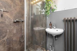 a bathroom with a shower with a sink and a mirror at Venture Vacation - Cozy and Central Apartment in Reykjavík