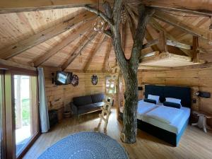 un dormitorio con una cama y un árbol dentro en EuroParcs Wörthersee, en Schiefling am See