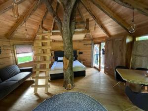 Cabaña de madera con cama y árbol en EuroParcs Wörthersee, en Schiefling am See