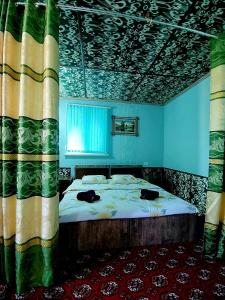 1 dormitorio con 1 cama en una habitación con paredes azules en B&B, Khiva ,, Abdullah " in ichan Kala, en Khiva