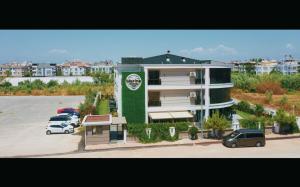 安塔利亞的住宿－LARA MARİNE HOMES，停车场内有车辆的建筑物