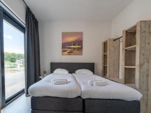 - une chambre avec un grand lit et une grande fenêtre dans l'établissement Water villa with garden near Harderwijk, à Zeewolde