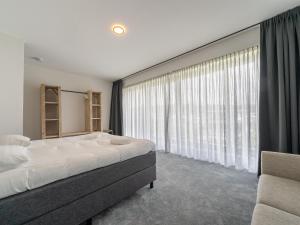 - une chambre avec un grand lit et une grande fenêtre dans l'établissement 16p group accommodation in 2 villas on the water, à Zeewolde