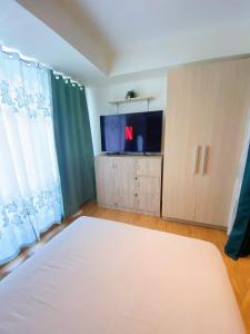1 dormitorio con 1 cama grande y TV en 1bedroom Suite near Airport en Manila