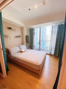 1 dormitorio con cama y ventana grande en 1bedroom Suite near Airport en Manila