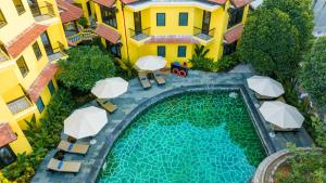 an overhead view of a swimming pool in a building with umbrellas at Oriental Boutique Hoi An in Hoi An