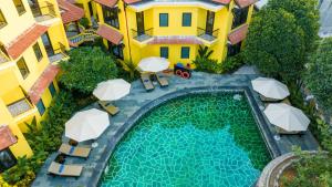 an overhead view of a swimming pool in a building with umbrellas at Lantern Boutique Hoi An in Hoi An