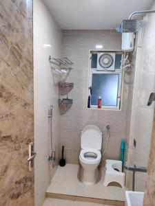 a bathroom with a toilet and a sink and a window at Vista Vibes in Chennai
