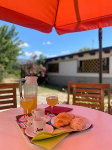 una mesa con un plato de comida y dos vasos de zumo de naranja en Il Melograno, en Francavilla Marittima