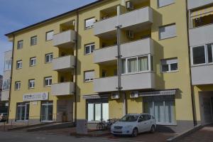 a yellow building with a car parked in front of it at Apartman Ana Pula - Calm, Free Parking, Close to Center in Pula