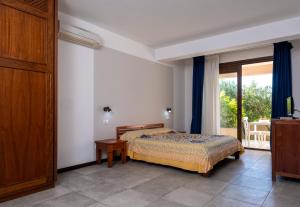 ein Schlafzimmer mit einem Bett und einem großen Fenster in der Unterkunft Moresco Resort in Lampedusa
