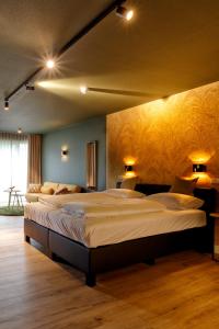 two beds in a room with two lamps on the wall at Wapen van Hengelo Residence Suites - digital key by email in Hengelo