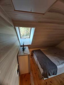a small bedroom with a bed and a window at Uroczy domek letniskowy z kominkiem 100m2 in Bogaczewo
