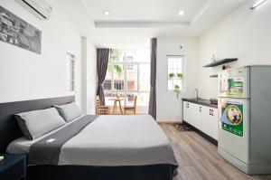 a bedroom with a large bed and a kitchen at Cali Homestay in Ho Chi Minh City