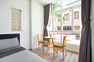 胡志明市的住宿－Cali Homestay，卧室配有一张床和一张桌子及椅子