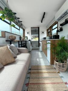 a living room with a couch and a kitchen at Leobus-לאו באס in Menaẖemya
