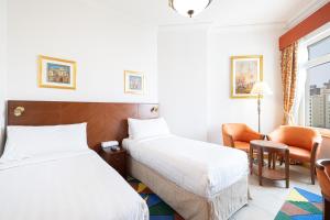 una habitación de hotel con 2 camas y una silla en Royal Club By RVHR, Palm Jumeirah, en Dubái
