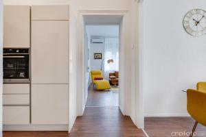 a hallway leading to a kitchen with a clock on the wall at Apartment Jadera in Zadar