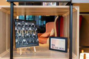 a book shelf with a picture and a sign on it at IntercityHotel Wien in Vienna