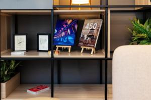 a book shelf with pictures and posters on it at IntercityHotel Wien in Vienna