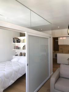- une chambre avec un lit et une porte coulissante en verre dans l'établissement Enormous charm T2 historic center laundry Fiber, à Perpignan