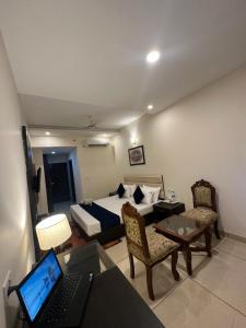 a bedroom with a bed and a desk with a laptop at Hotel JB Residency !! Luxurious & Royal Balcony Rooms !! Large Rooms in Zirakpur