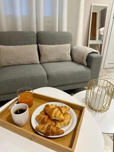 a tray with a plate of croissants on a table at Venetian Gem Central Corfu Retreat in Kanoni