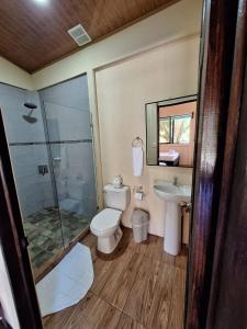 a bathroom with a toilet and a sink and a shower at The Secret Eco Lodge in Tortuguero