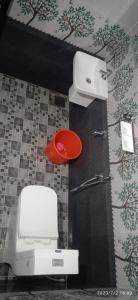 a bathroom with a white toilet and a red stool at White Rose in Chekadi