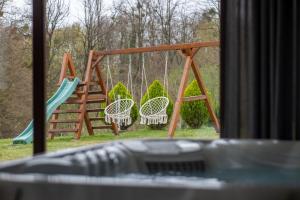a playground with two chairs and a swing at Holiday Home AdaliA in Štrigova