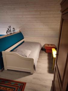 Ce lit se trouve dans un dortoir doté d'un mur en bois. dans l'établissement Chambre d'hôtes à la campagne "Le coudry", à Serley