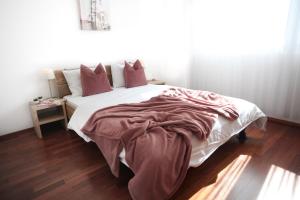 1 dormitorio con 1 cama blanca grande con almohadas rojas en Nest - Bundesstrasse 6, en Zug