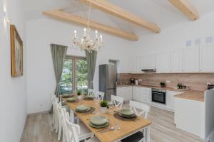 a kitchen and dining room with a wooden table and chairs at Mieszkanie pod Lipą 