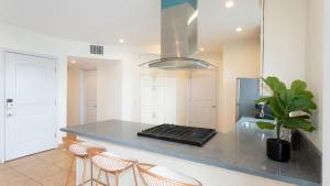 a kitchen with a counter with stools and a refrigerator at Three-Bedroom Hollywood Condo in Los Angeles